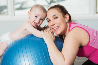 A woman with a baby on an exercise ball